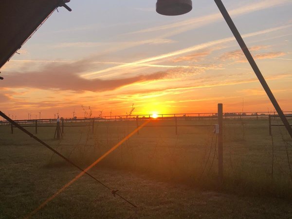 Zonsondergang door de tentopening met lantaarn